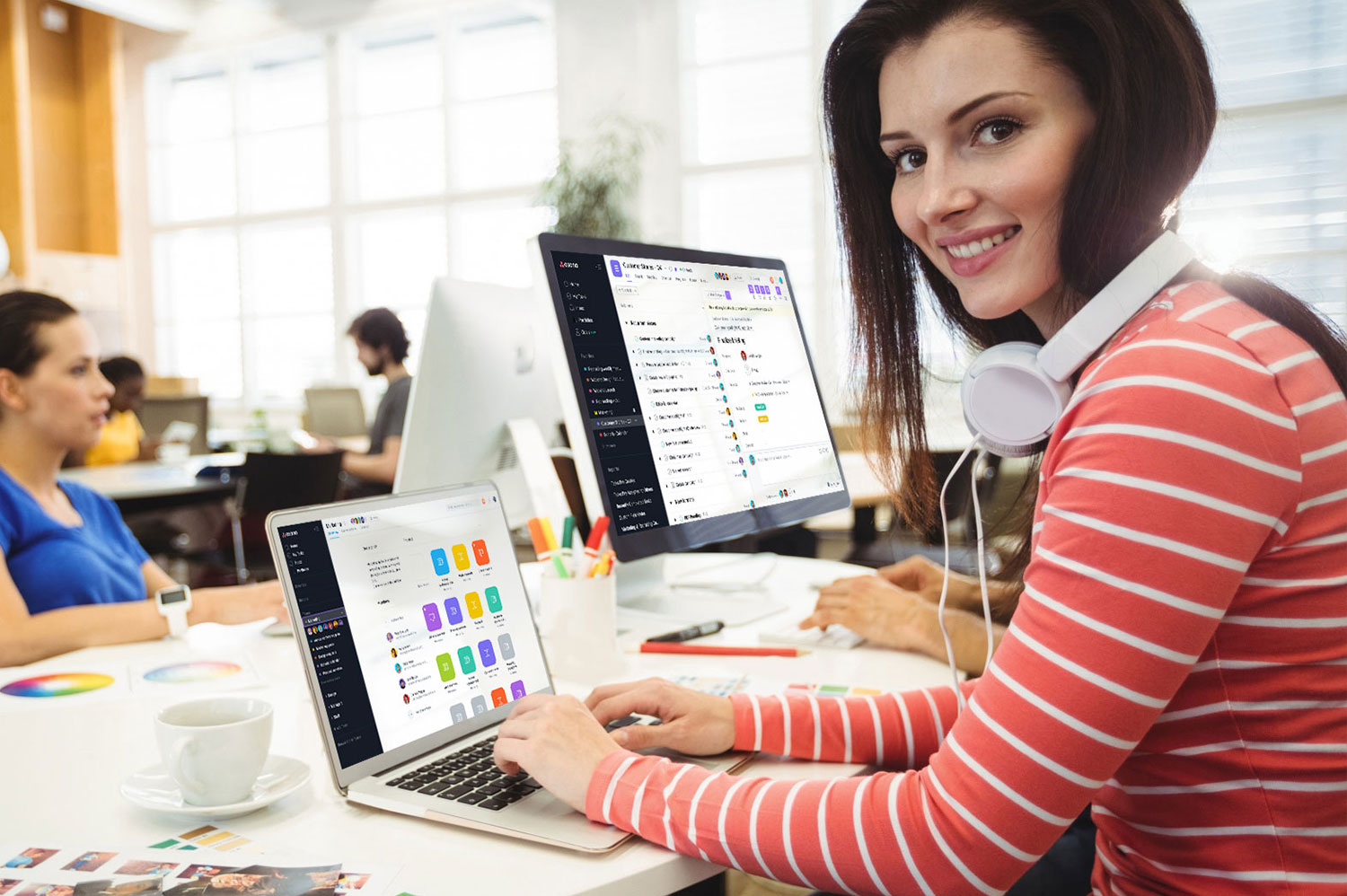 graphic designer looking camera while colleague working ba